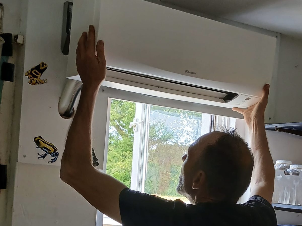 Installateur van KlimaaTec hangt het binnendeel van een airco op