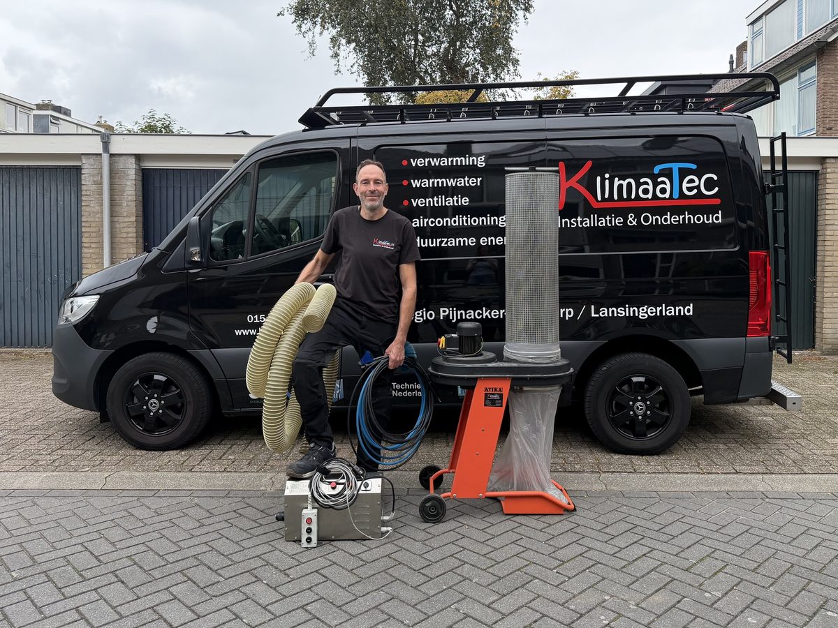 Peter Bloemberg bij de KlimaaTec-bus met de reinigingsmachine, de afzuiginstallatie en de slangen voor het reinigen van ventilatiekanalen