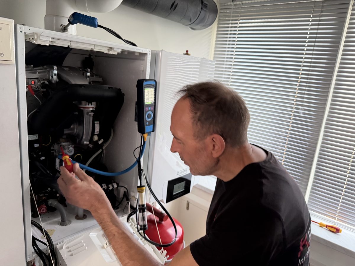 Peter Bloemberg aan het werk aan een geopende cv-ketel