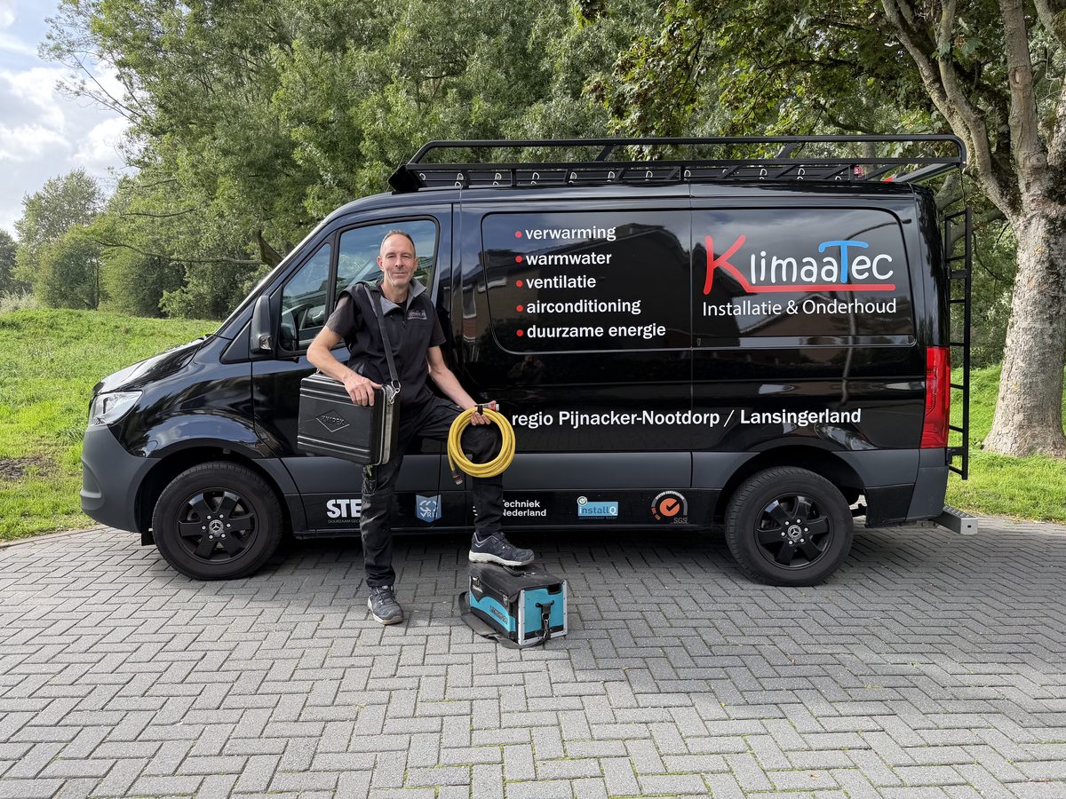 Peter Bloemberg van KlimaaTec bij zijn bedrijfsbus met gereedschapskoffers