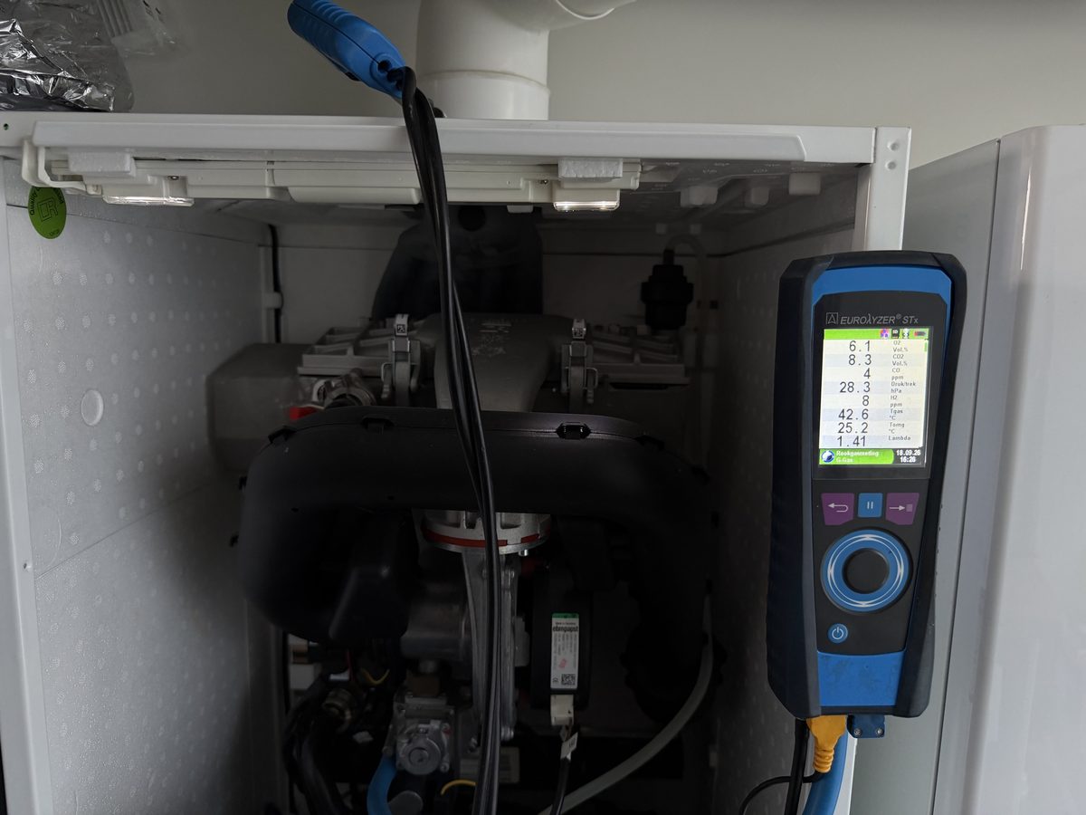 Rookgasmeter aangesloten op een geopende cv-ketel tijdens onderhoud