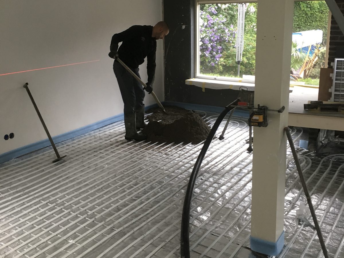 De dekvloer wordt over de vloerverwarmingsbuizen gestort